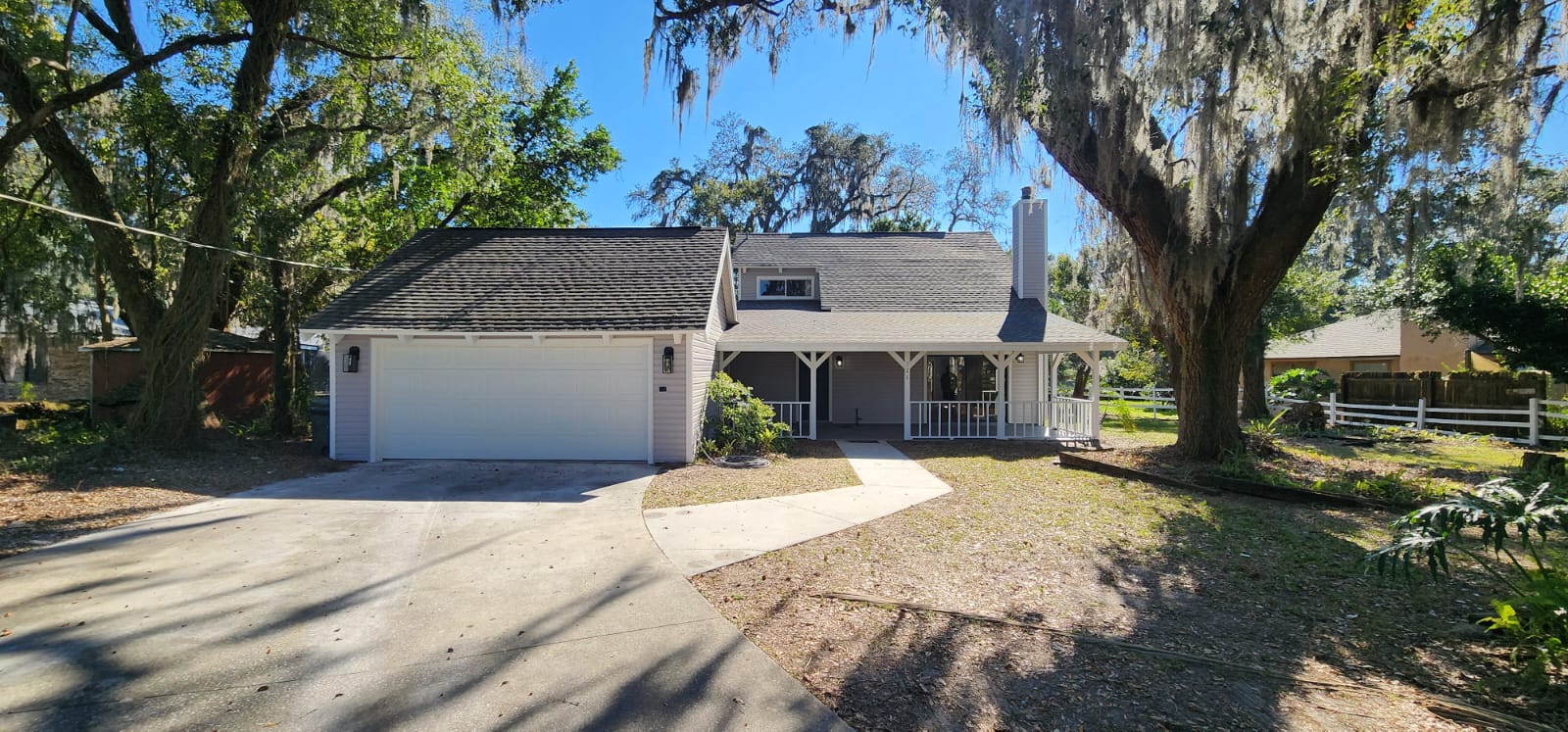 Two-story Florida home framed by Spanish moss